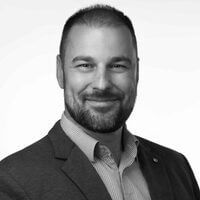 Andrejcsik-Gabor-Egysezrű-Pénz-kft Andrejcsik Gábor portréképe fehér háttér előtt, elegáns zakóban és világos lila ingben mosolyogva – a fotó egy ügyfélvéleményhez készült, amelyben Gábor elmondja pozitív tapasztalatait.