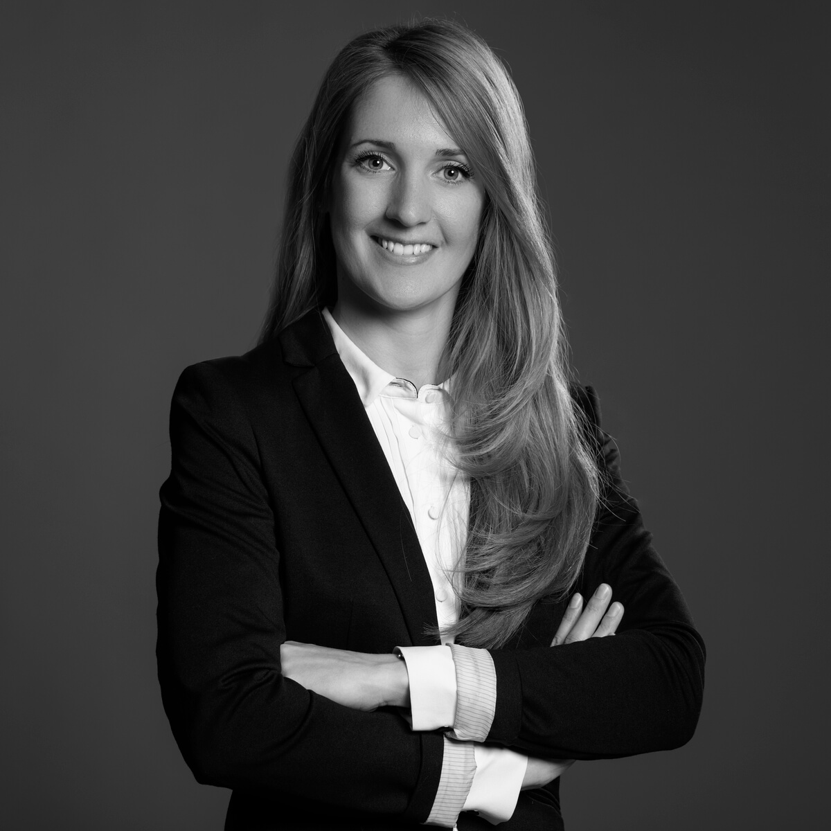 Dr. Kovács Nóra Dr. Kovács Nóra portréja üzleti öltözetben, magabiztos testtartással, sötét háttér előtt – Professzionális ingatlanjogi ügyintézés specialistája, elegáns megjelenéssel.