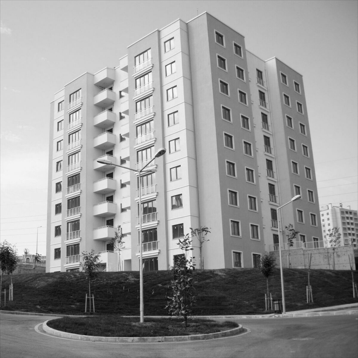 Közös képviselők földhivatali regisztrációja társasházban Modern társasház több emeletes épülete parkosított környezetben, amely a közös képviselők földhivatali regisztrációja folyamatának fontosságára utal.