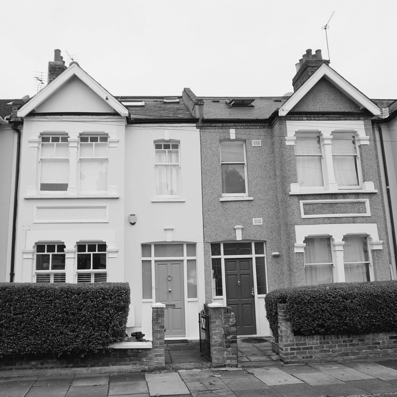 Két egymás mellett álló sorház homlokzata, közös kapuval és előkerttel. A kép jól szemlélteti, milyen gyakorlati kérdések merülhetnek fel a közös tulajdon megszüntetése során, például a közös bejárat, a kerítés vagy a közös használatú területek megosztása