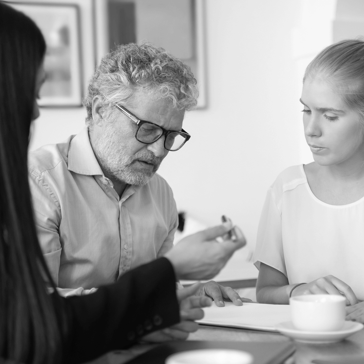Ügyvéd és ügyfelek közösen átbeszélik az ingatlan haszonélvezeti jogával kapcsolatos dokumentumokat egy irodában, részletes jogi tanácsadás közben.